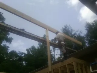 Carpenter setting a ridge beam over a new addition frame — Ice Dam Removal by Roofing Brothers in Mekinock
