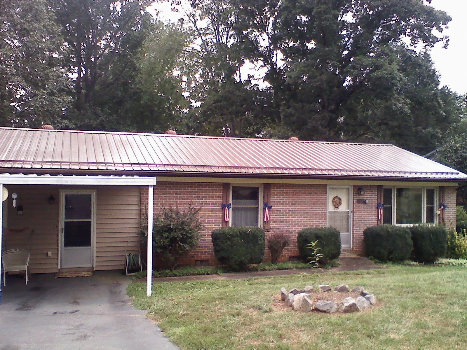 Bronze metal roof and carport on a brick ranch home — Roof Repair work by our crew in Mekinock