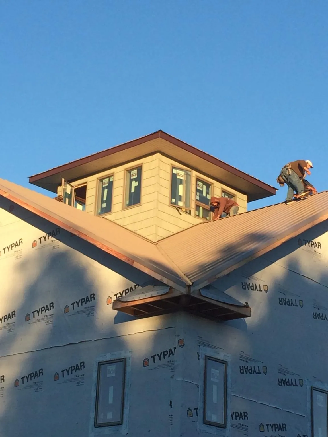 Roofers working around a rooftop cupola on a new metal roof at sunset — Roof Waterproofing in Mekinock by Roofing Brothers
